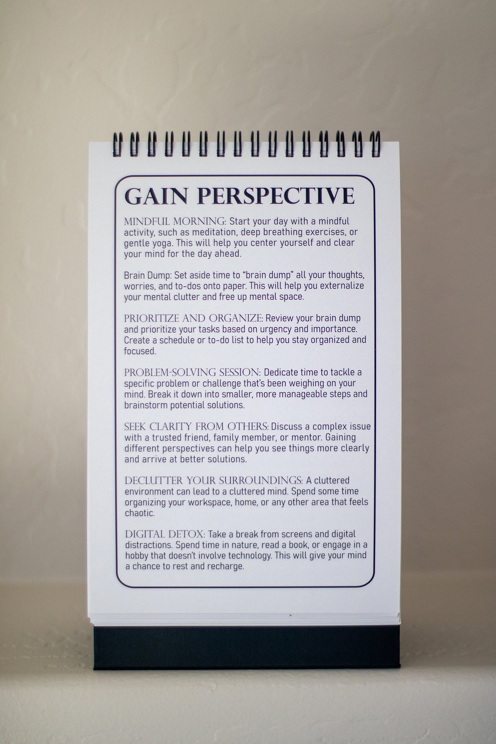 An image of the 52-Week Self-Improvement and Character Development Flip Book displaying the "Gain Perspective" page. The page features suggestions for activities to help clear the mind and find focus, such as journaling, prioritizing tasks, and seeking clarity from others.