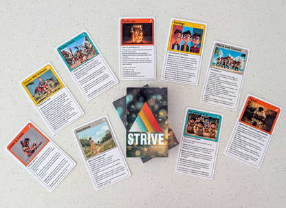 A flat lay of the activity cards for children.  Ten cards are fanned out around the deck's packaging, each featuring unique artwork and titles. Some examples include "Conquer With Kindness," "Listen & Create," and "Peace."