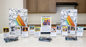 A display of the activity cards for children, activity cards for personal growth and 52-week flip book. Several cards with diverse artwork are showcased on stands, alongside two open calendars and three packaged decks. The STRIVE logo is prominent on the calendars and card backs.